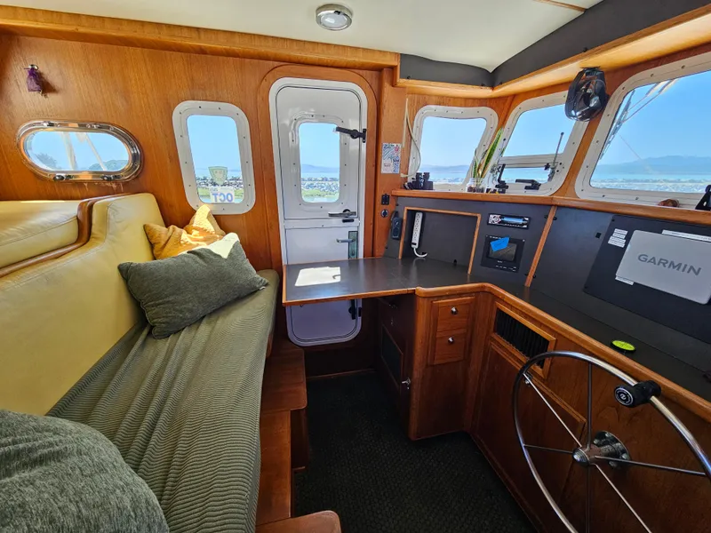 Slide: The Image of Cozy 2002 Nordhavn Trawler interior with helm, seating, and navigation equipment. - 18