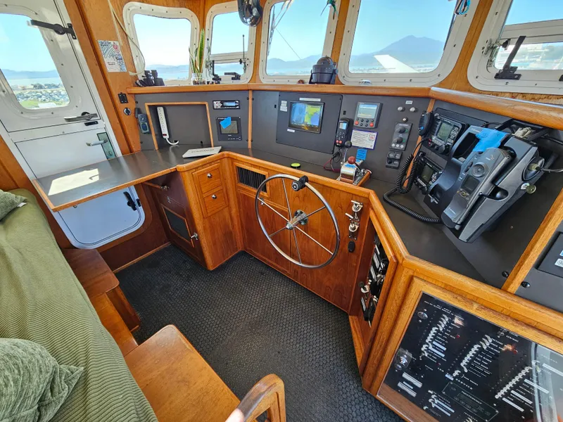 Slide: The Image of Pilothouse of a 2002 Nordhavn Trawler with navigation equipment and wooden interior. - 26