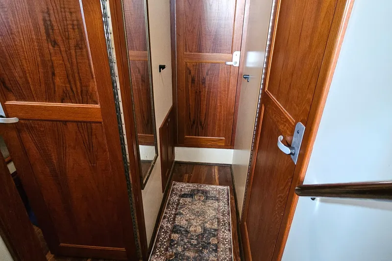 Slide: The Image of Hallway inside 2002 Nordhavn Trawler with wooden doors and decorative rug. - 27