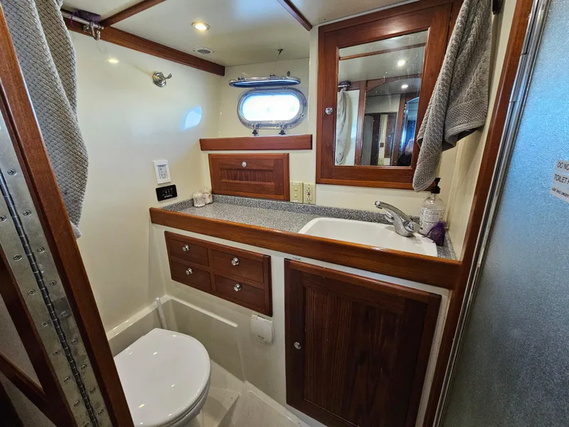 Slide: The Image of Bathroom interior of 2002 Nordhavn Trawler with wood accents and porthole window. - 30