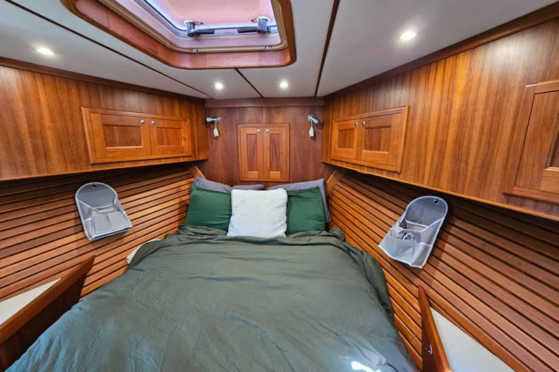 Slide: The Image of Cozy cabin interior of a 2002 Nordhavn Trawler with wood paneling and a skylight. - 34