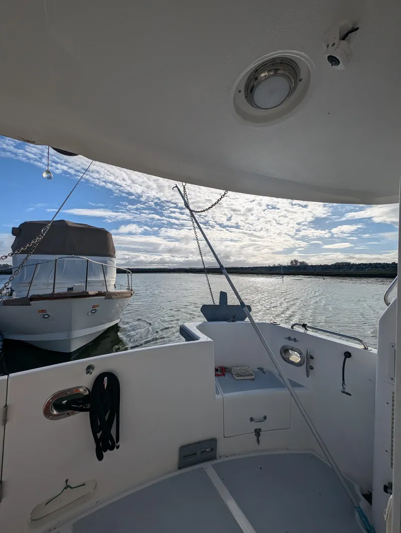 Slide: The Image of 2002 Nordhavn Trawler docked, view from deck, calm waters, partly cloudy sky. - 39
