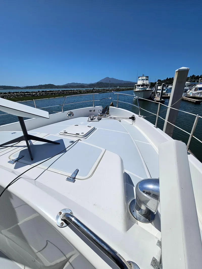 Slide: The Image of 2002 Nordhavn Trawler on water, docked at marina with clear blue sky. - 45