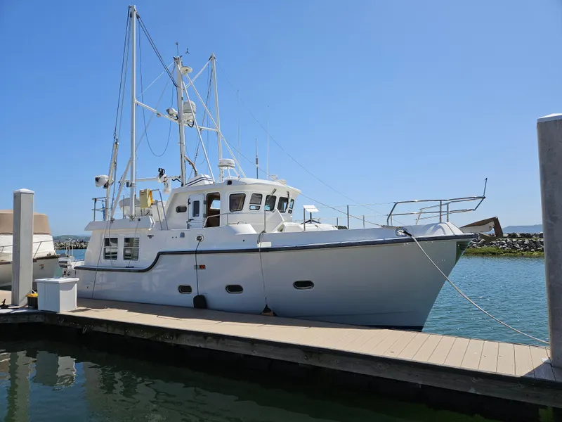 Slide: The Image of 2002 Nordhavn Trawler docked at marina under clear blue sky. - 46