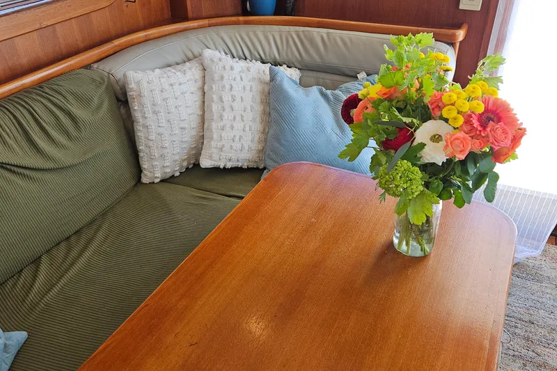 Slide: The Image of Cozy Nordhavn 2002 trawler interior with floral arrangement on wooden table. - 5