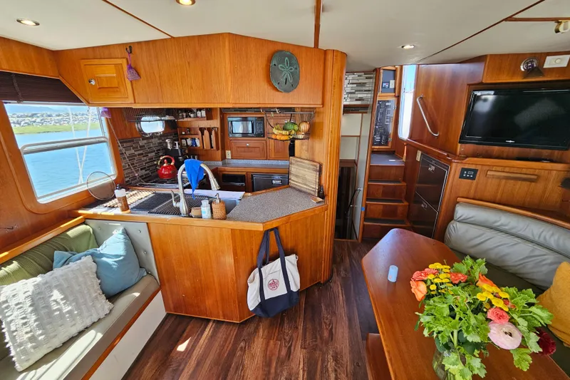 Slide: The Image of Interior of a 2002 Nordhavn Trawler with cozy seating, kitchen, and dining area. - 6