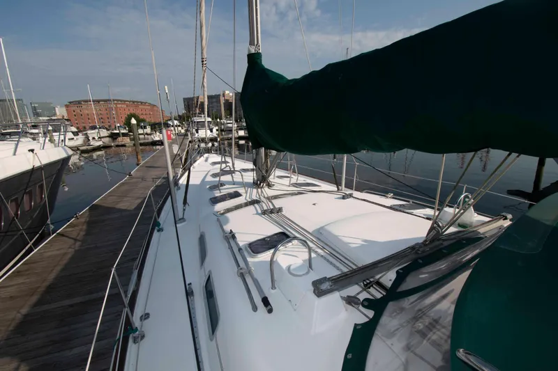 Slide: The Image of Beneteau 473 sailboat docked at marina, 2002 model, with clear sky and calm water. - 12