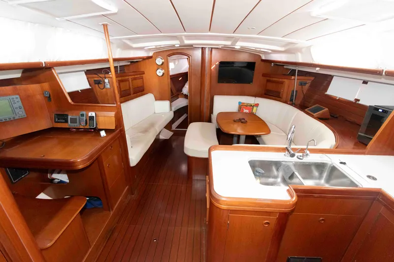 Slide: The Image of Interior of 2002 Beneteau 473 yacht with wood finish, seating, and kitchenette. - 16