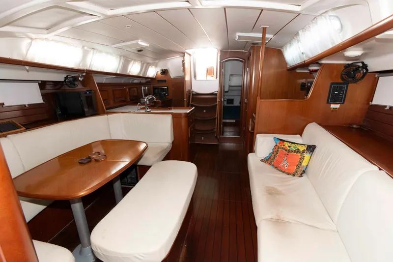 Slide: The Image of Interior of 2002 Beneteau 473 yacht with wooden finishes and white seating. - 17