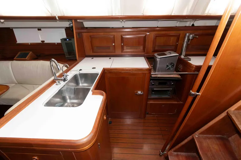 Slide: The Image of Luxurious 2002 Beneteau 473 yacht interior with wooden cabinetry and modern kitchen amenities. - 18