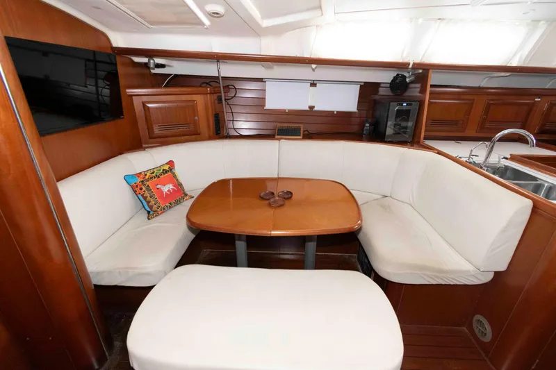 Slide: The Image of Interior of 2002 Beneteau 473 yacht with cozy dining area and wooden finishes. - 19