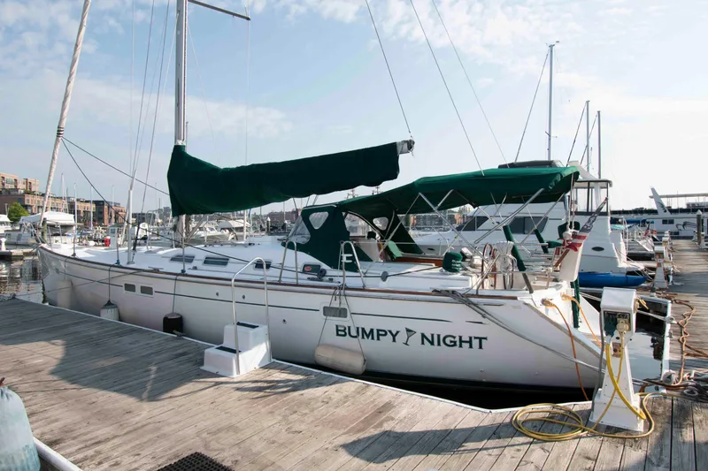 Slide: The Image of 2002 Beneteau 473 sailboat docked at marina, named "Bumpy Night." - 2