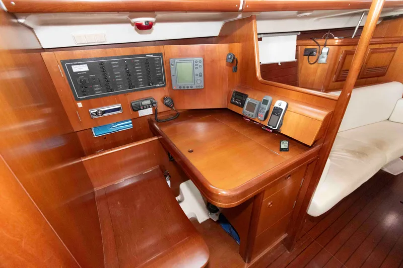 Slide: The Image of Navigation station of 2002 Beneteau 473 yacht with control panels and seating. - 22