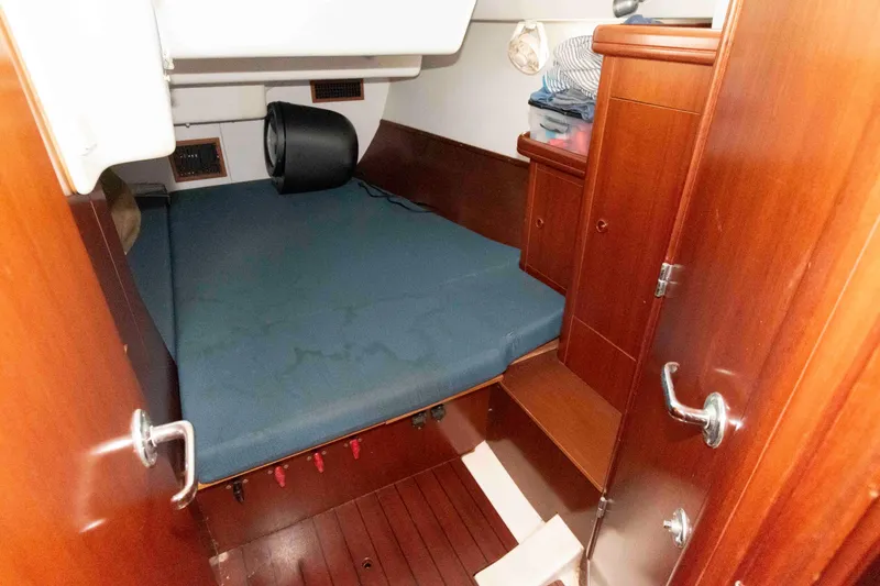 Slide: The Image of Cozy cabin interior of 2002 Beneteau 473 sailboat with wooden finish and blue mattress. - 26