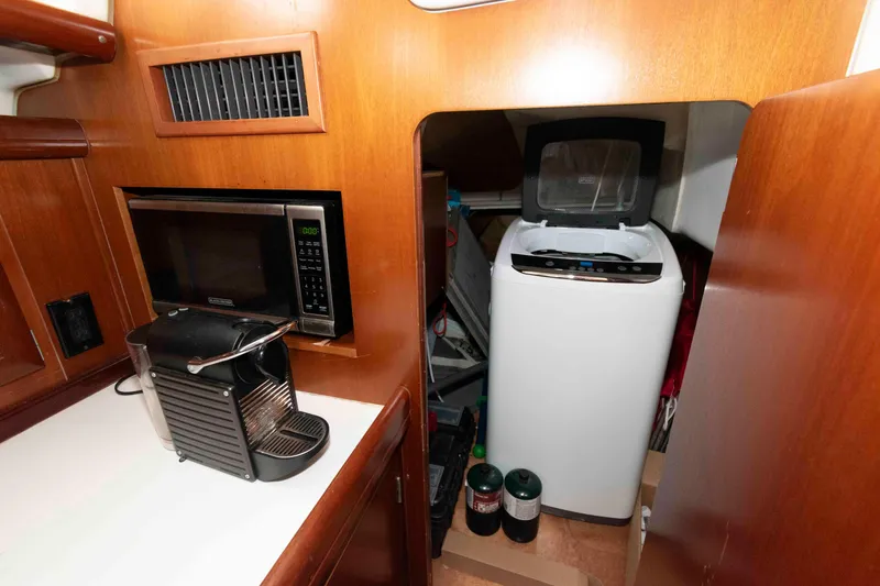 Slide: The Image of Galley of 2002 Beneteau 473 with microwave, coffee maker, and compact washing machine. - 28