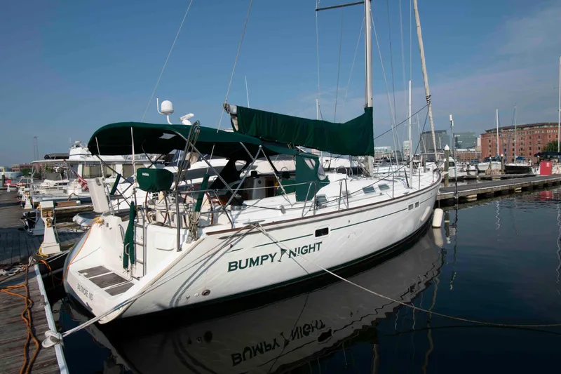 Slide: The Image of 2002 Beneteau 473 sailboat docked at marina, named "Bumpy Night." - 3