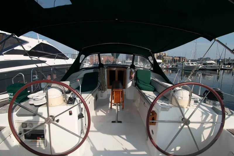 Slide: The Image of Beneteau 473 sailboat cockpit, dual steering wheels, marina background, 2002 model. - 5