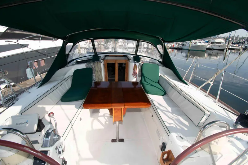 Slide: The Image of Cockpit of 2002 Beneteau 473 sailboat with green canopy and wooden table. - 6