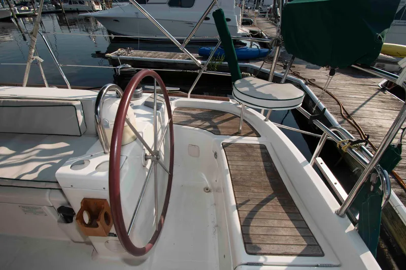 Slide: The Image of Cockpit of a 2002 Beneteau 473 sailboat with wooden deck and steering wheel. - 8