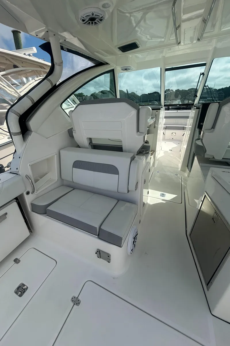 Slide: The Image of 2023 Pursuit DC326 boat helm with steering wheel and control panel. - 11