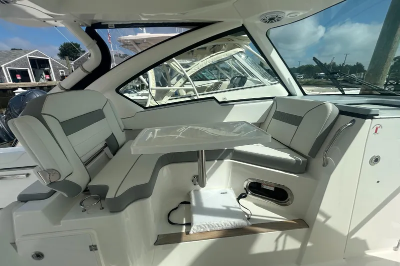 Slide: The Image of 2023 Pursuit DC326 boat interior with open hatch, showcasing sleek design and marina view. - 15