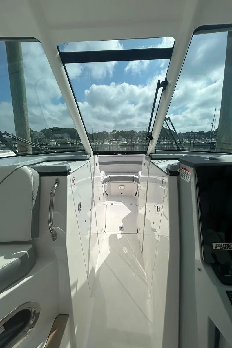 Slide: The Image of 2023 Pursuit DC326 boat interior with life jackets, sink, and storage area. - 16
