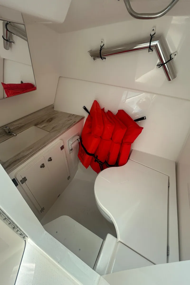 Slide: The Image of 2023 Pursuit DC326 boat interior with cushioned seating, docked at marina. - 17