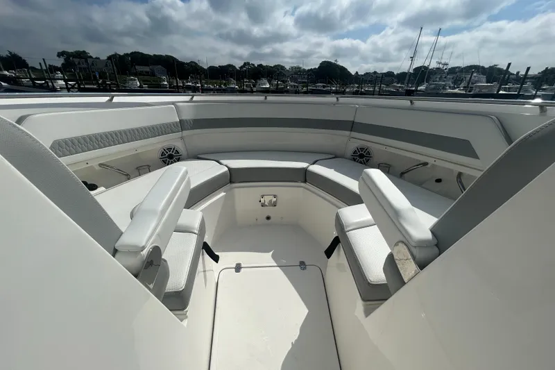 Slide: The Image of 2023 Pursuit DC326 boat interior with seating and table, docked at marina. - 19