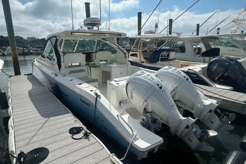 Slide: The Image of 2023 Pursuit DC326 boat docked, featuring dual outboard engines and sleek design. - 5