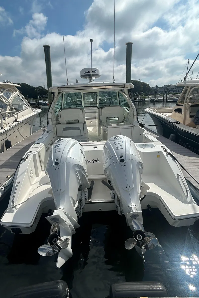 Slide: The Image of 2023 Pursuit DC326 boat with dual outboard engines docked at a marina. - 6