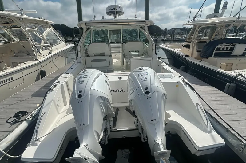 Slide: The Image of 2023 Pursuit DC326 boat with dual outboard engines docked at a marina. - 7