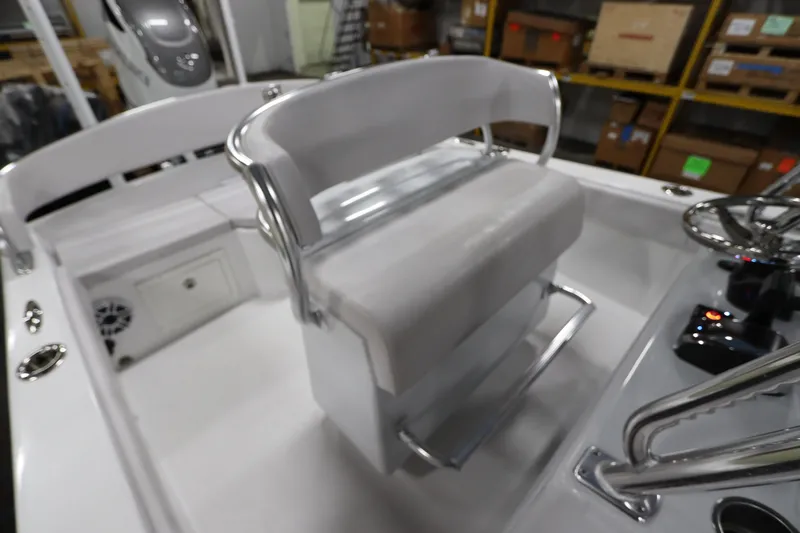 Slide: The Image of 2024 SeaCraft 23CC boat interior with white seating and steering console. - 24