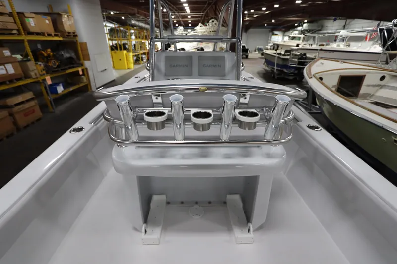 Slide: The Image of 2024 SeaCraft 23CC boat interior with rod holders and Garmin equipment in a warehouse setting. - 26