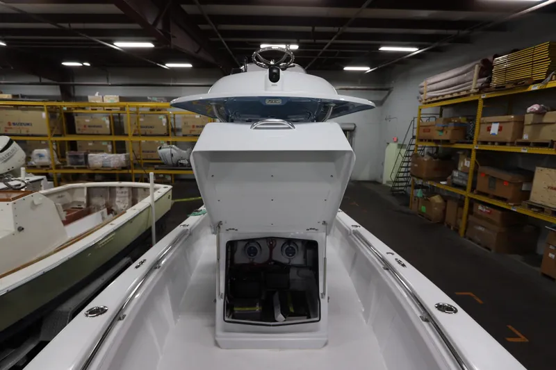 Slide: The Image of 2024 SeaCraft 23CC boat in warehouse, open storage compartment, surrounded by shelves and equipment. - 43