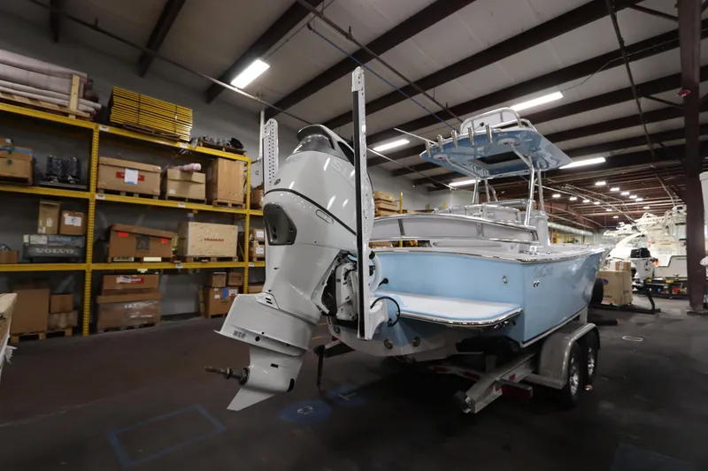 Slide: The Image of 2024 SeaCraft 23CC boat in warehouse, featuring a powerful outboard motor. - 5