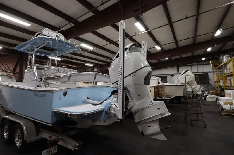 Slide: The Image of 2024 SeaCraft 23CC boat in warehouse, featuring dual outboard motors. - 13