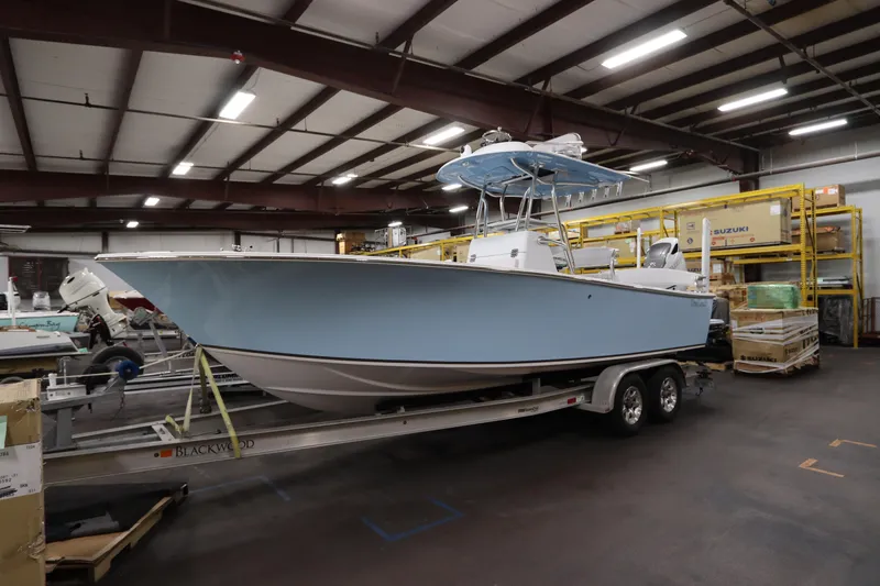 Slide: The Image of 2024 SeaCraft 23CC boat in warehouse, light blue hull on trailer. - 4