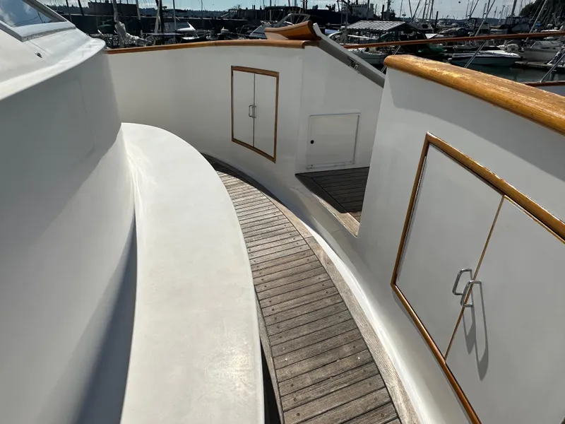 Slide: The Image of 1985 Ocean Alexander Pilothouse yacht deck with wooden trim and storage compartments. - 10