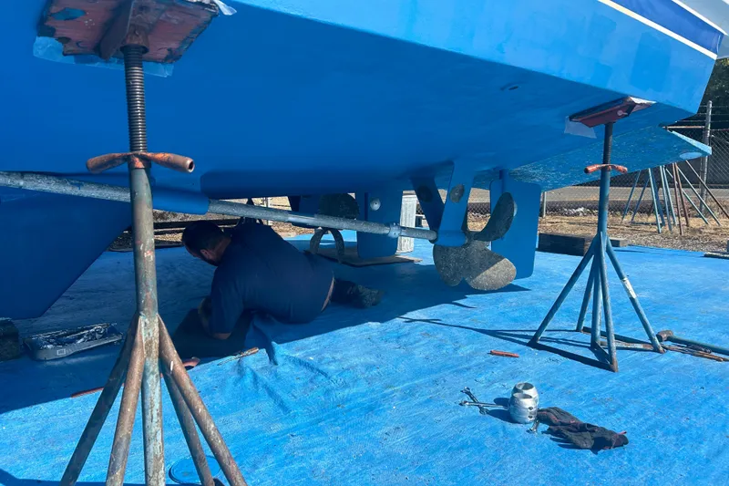 Slide: The Image of 1985 Ocean Alexander Pilothouse undergoing maintenance with worker beneath, supported by stands. - 104