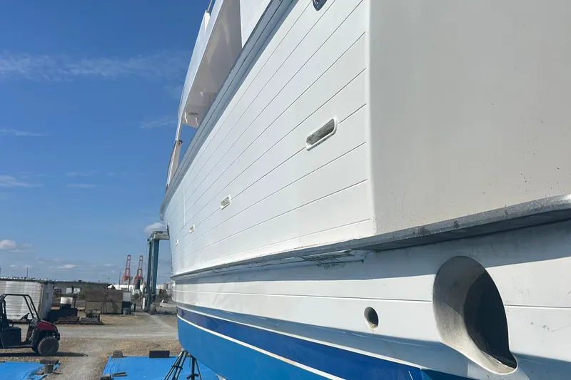 Slide: The Image of 1985 Ocean Alexander Pilothouse yacht on dry dock, showcasing white and blue hull. - 106