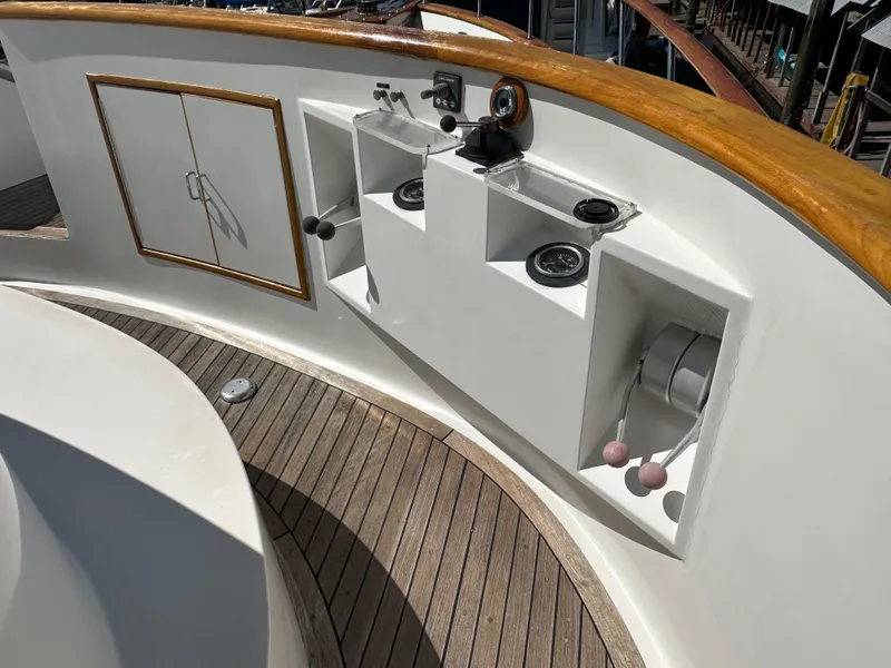 Slide: The Image of 1985 Ocean Alexander Pilothouse yacht deck with wooden trim and built-in storage compartments. - 13