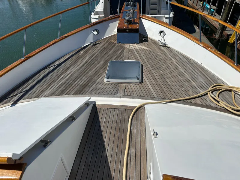 Slide: The Image of 1985 Ocean Alexander Pilothouse yacht deck with wooden finish and railing. - 15