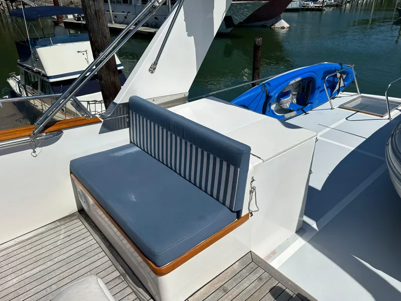 Slide: The Image of 1985 Ocean Alexander Pilothouse yacht deck with blue seating and kayak. - 23