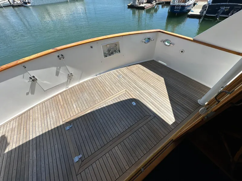Slide: The Image of 1985 Ocean Alexander Pilothouse yacht deck with wooden flooring, docked at marina. - 29
