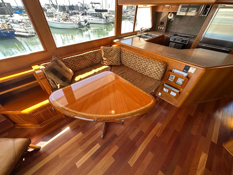 Slide: The Image of Luxurious 1985 Ocean Alexander Pilothouse interior with wood finishes and marina view. - 37