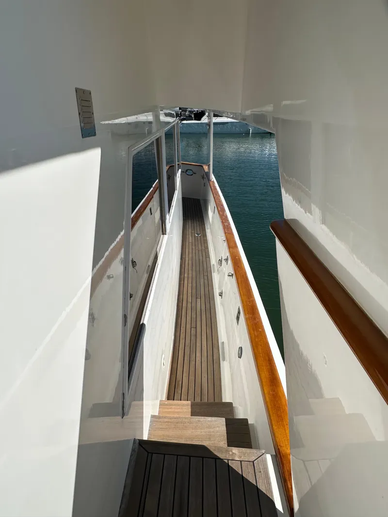 Slide: The Image of 1985 Ocean Alexander Pilothouse yacht with wooden deck and white exterior, docked at marina. - 6