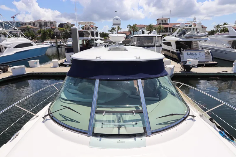 Slide: The Image of 2004 Sea Ray 420 Sundancer yacht docked at a marina under a partly cloudy sky. - 10