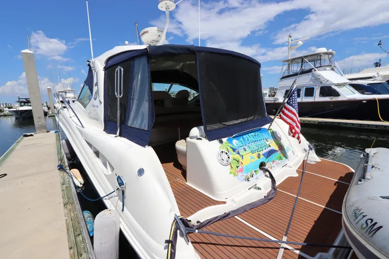 Slide: The Image of 2004 Sea Ray 420 Sundancer docked, featuring a colorful banner and American flag. - 12
