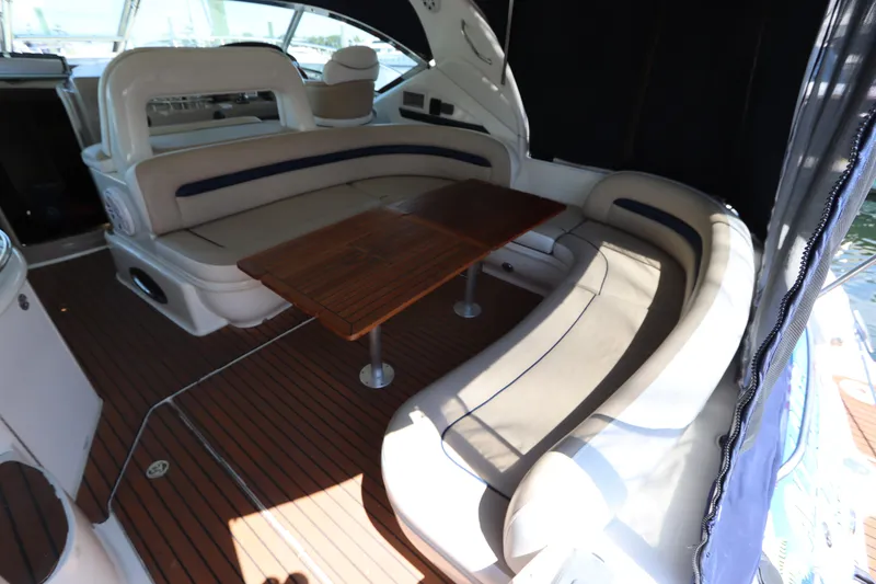 Slide: The Image of 2004 Sea Ray 420 Sundancer interior with curved seating and wooden table. - 13