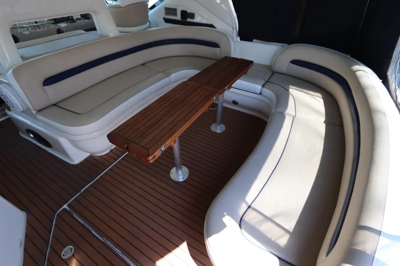Slide: The Image of Luxurious seating area on 2004 Sea Ray 420 Sundancer yacht with wooden table and cushioned benches. - 14
